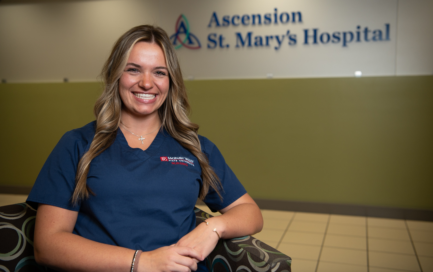 Young woman in scrubs in lobby of Ascension St. Mary's Hospital